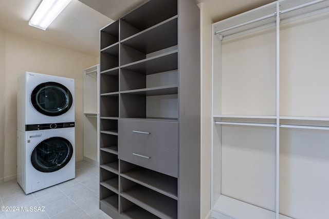 laundry area featuring tile patterned flooring, stacked washer and clothes dryer, and laundry area