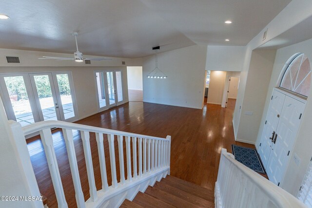 stairs with wood-type flooring, lofted ceiling, and ceiling fan