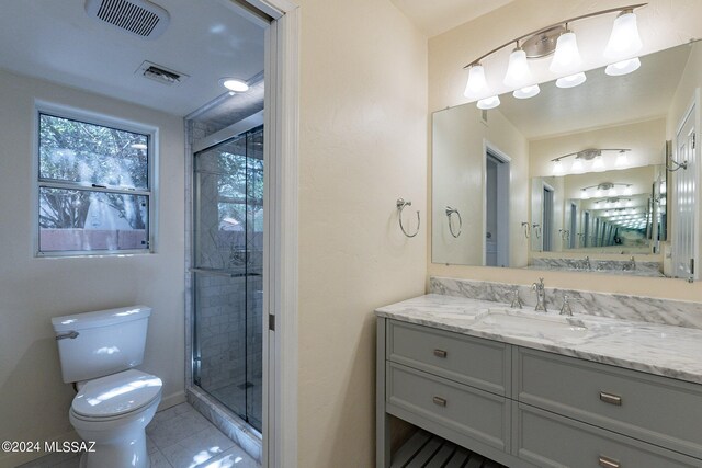 bathroom featuring vanity, toilet, tile patterned floors, and a shower with door