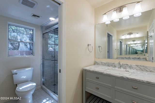 bathroom featuring toilet, vanity, a shower stall, and visible vents