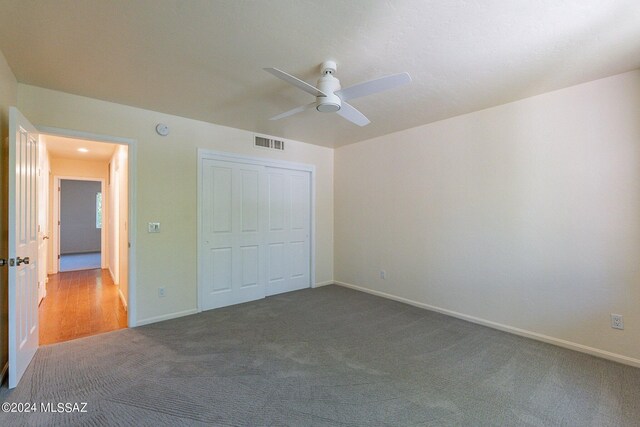 unfurnished bedroom with ceiling fan, carpet floors, and a closet