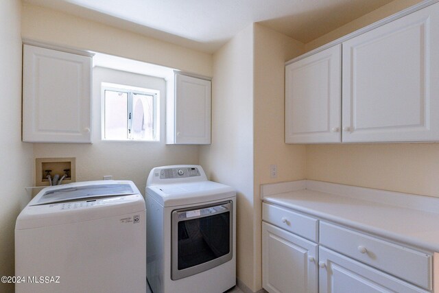 washroom featuring cabinets and washing machine and clothes dryer