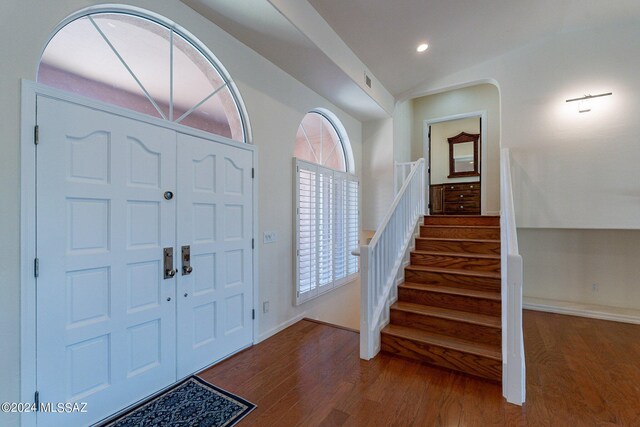 foyer entrance featuring wood-type flooring and vaulted ceiling