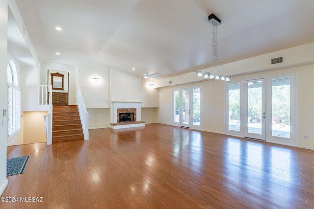 unfurnished living room featuring wood-type flooring, vaulted ceiling, ceiling fan, and french doors