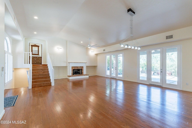 unfurnished living room with visible vents, hardwood / wood-style flooring, a fireplace with raised hearth, recessed lighting, and a ceiling fan