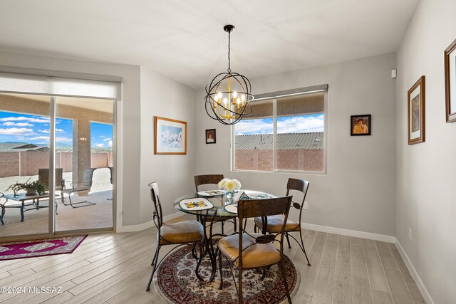 dining area featuring light hardwood / wood-style flooring, a wealth of natural light, and a notable chandelier