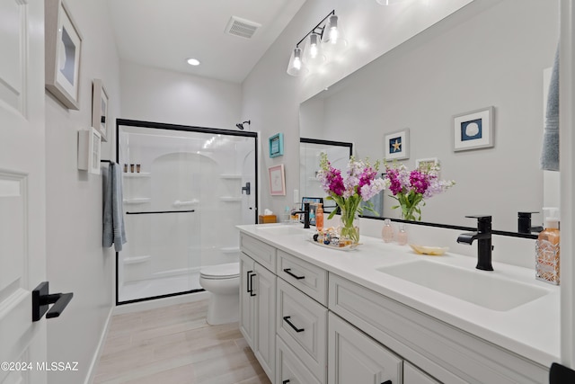 bathroom with walk in shower, vanity, hardwood / wood-style floors, and toilet