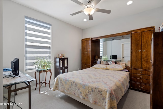 bedroom featuring ceiling fan, light colored carpet, high quality fridge, and a barn door