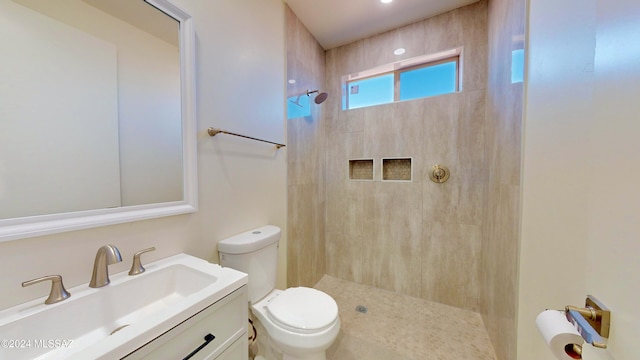 bathroom featuring vanity, toilet, and tiled shower