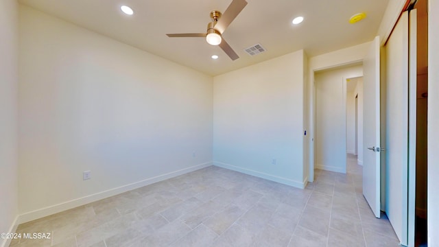 tiled spare room featuring ceiling fan