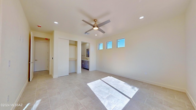 unfurnished bedroom featuring light tile patterned floors, ensuite bath, and ceiling fan