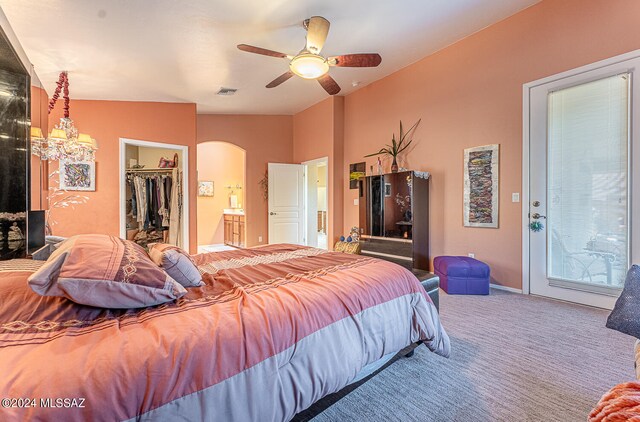 bedroom featuring ceiling fan, carpet, a walk in closet, a closet, and vaulted ceiling