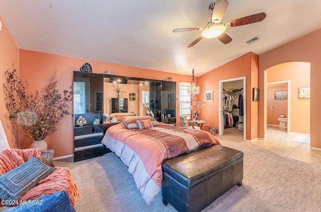 bedroom with light tile patterned flooring, vaulted ceiling, a closet, ceiling fan, and a walk in closet