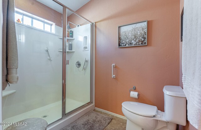 bathroom featuring tile patterned floors, an enclosed shower, and toilet