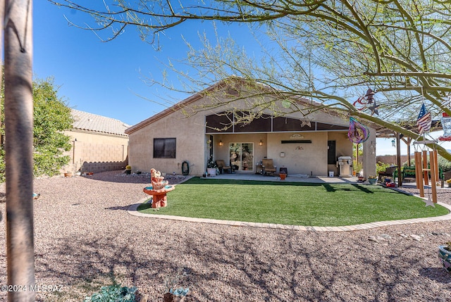 back of house with a yard and a patio