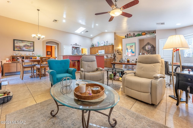 living room with ceiling fan with notable chandelier, vaulted ceiling, and light tile patterned floors