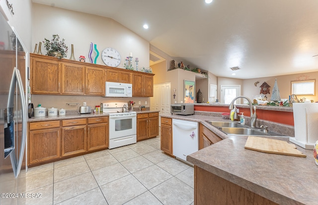 kitchen with lofted ceiling, white appliances, light tile patterned flooring, and sink