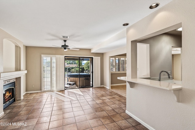 unfurnished living room featuring ceiling fan and tile patterned floors