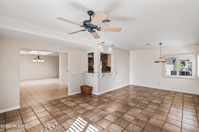 unfurnished living room featuring ceiling fan with notable chandelier