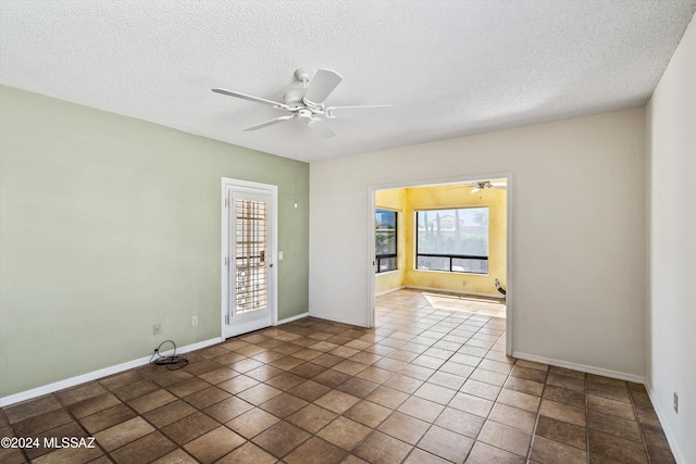 tiled empty room featuring a textured ceiling and ceiling fan