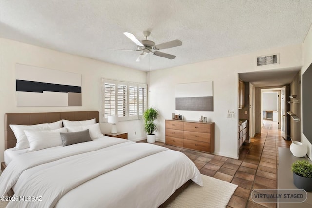 bedroom featuring ceiling fan and a textured ceiling