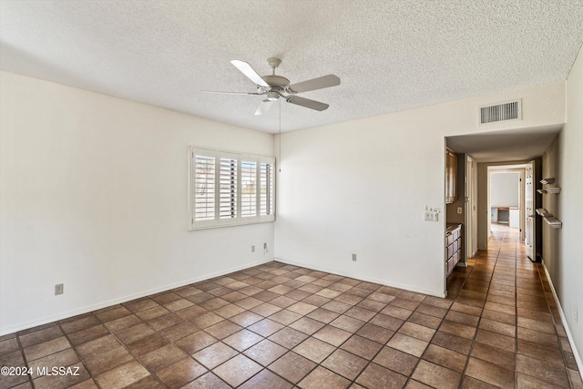 spare room featuring ceiling fan and a textured ceiling