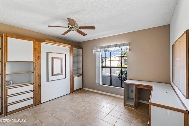 interior space with ceiling fan, a textured ceiling, and light tile patterned floors