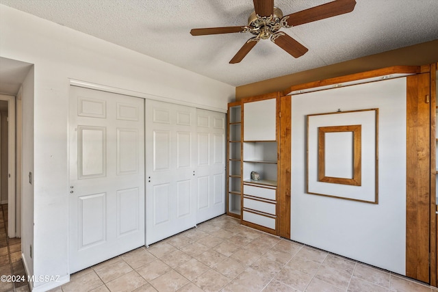 unfurnished bedroom with ceiling fan, a closet, and a textured ceiling