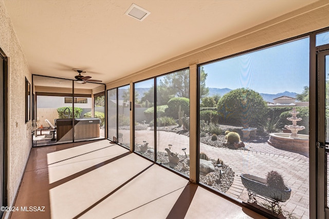 sunroom featuring a mountain view and ceiling fan