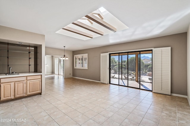 interior space featuring sink, a skylight, a chandelier, and plenty of natural light