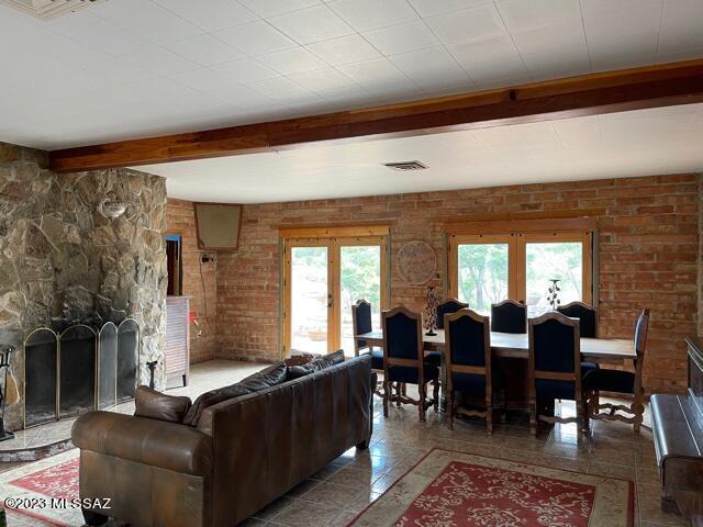 living room featuring brick wall, a chandelier, and sink