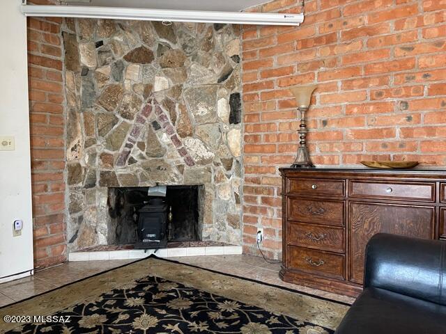 living room featuring french doors, beamed ceiling, a fireplace, and a healthy amount of sunlight