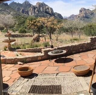 view of patio / terrace with an outdoor fire pit and a mountain view