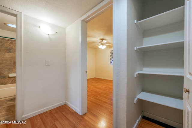 hallway featuring a textured ceiling and wood-type flooring