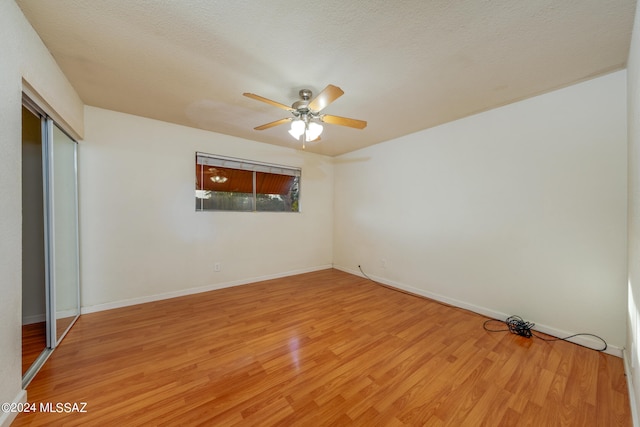 unfurnished bedroom featuring ceiling fan, a textured ceiling, a closet, and light hardwood / wood-style flooring