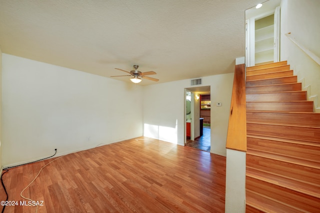 interior space featuring ceiling fan, hardwood / wood-style floors, and a textured ceiling