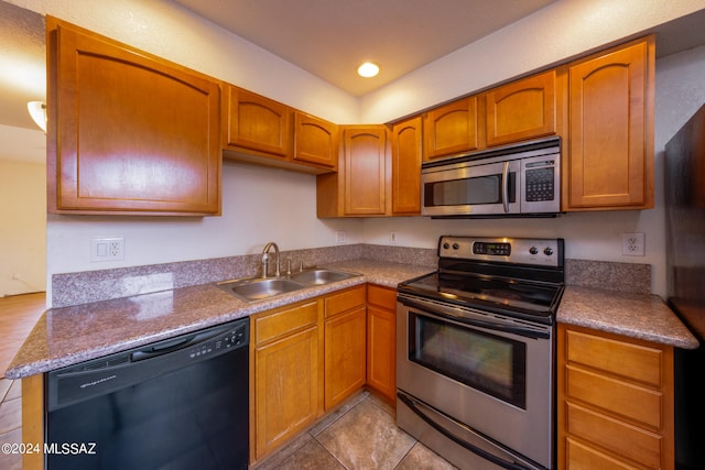 kitchen featuring light tile patterned flooring, sink, and stainless steel appliances