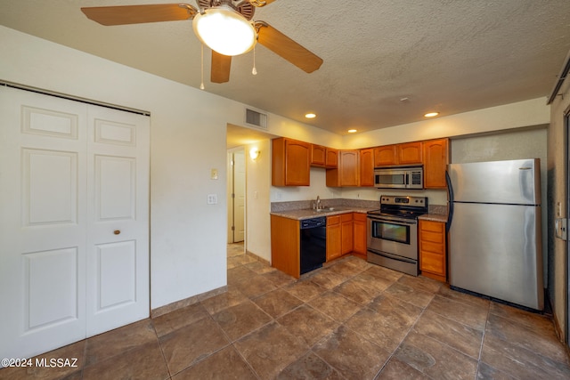 kitchen featuring stainless steel appliances, ceiling fan, a textured ceiling, and sink