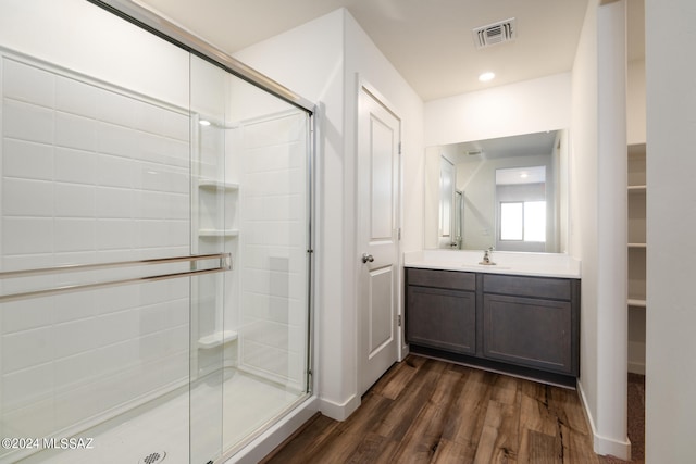 bathroom featuring a stall shower, baseboards, wood finished floors, and vanity