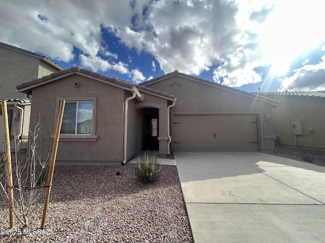 single story home featuring stucco siding, concrete driveway, and an attached garage