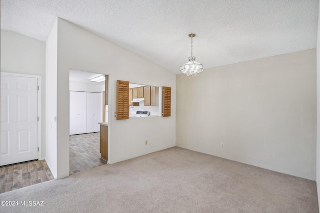 interior space featuring a textured ceiling, lofted ceiling, and an inviting chandelier