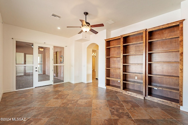 unfurnished living room featuring french doors and ceiling fan