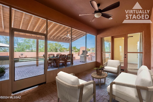 sunroom / solarium with ceiling fan and lofted ceiling with beams