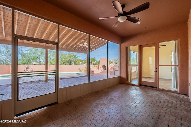 unfurnished sunroom featuring plenty of natural light, lofted ceiling, and ceiling fan