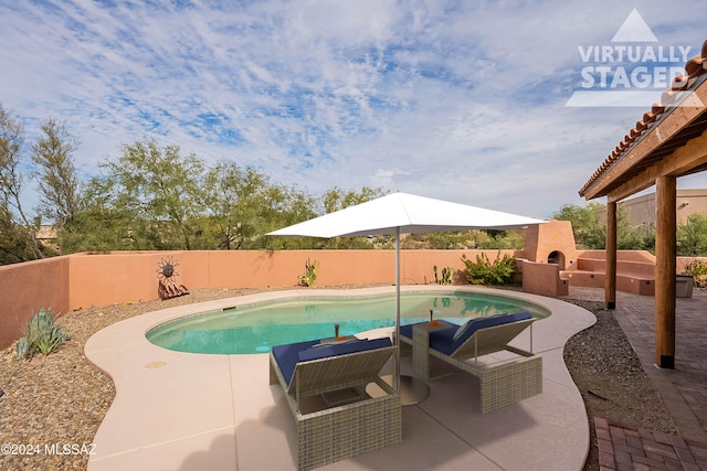 view of swimming pool with a patio area and exterior fireplace