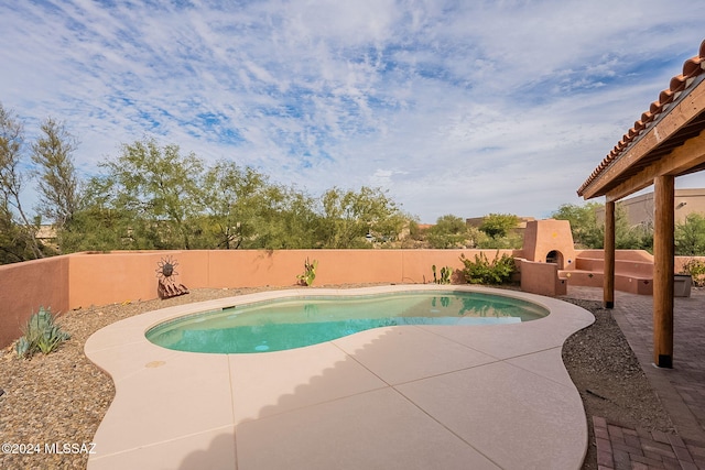 view of pool with a patio area and exterior fireplace