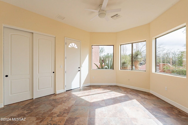 unfurnished sunroom featuring ceiling fan