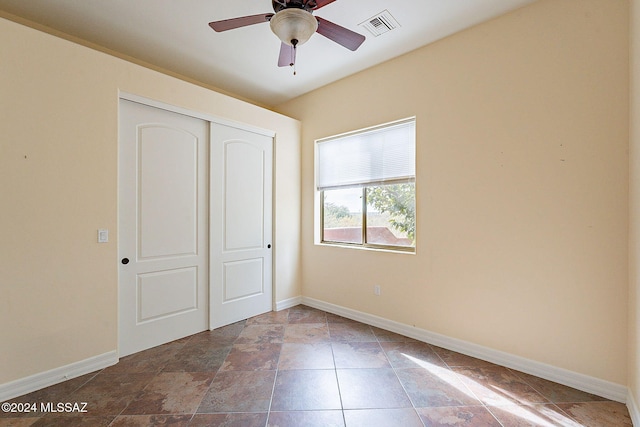 unfurnished bedroom featuring ceiling fan and a closet