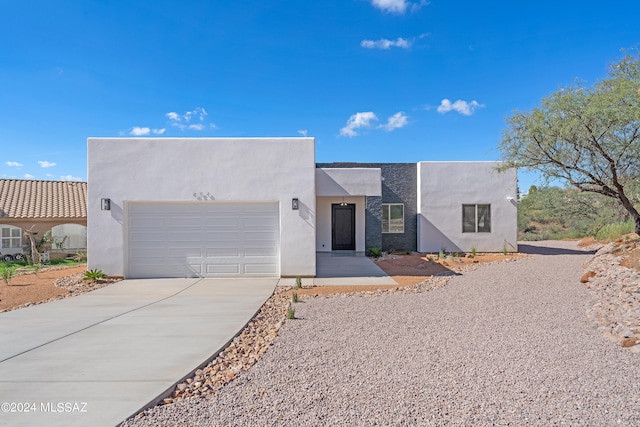 pueblo revival-style home featuring a garage