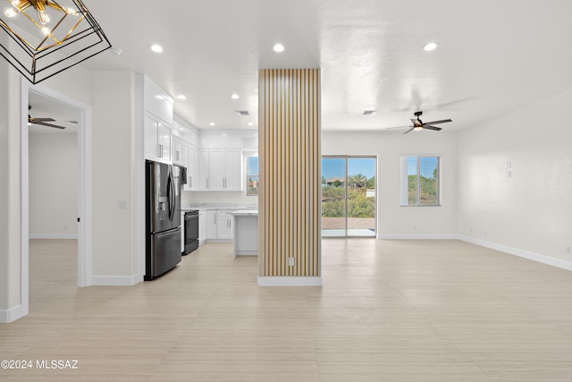 kitchen with ceiling fan, stainless steel fridge, black range oven, and white cabinetry